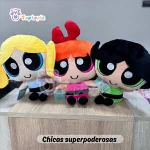 Set de peluches de Las Chicas Superpoderosas con Bombón, Burbuja y Bellota, cada una con su vestido y colores característicos, exhibidas juntas sobre fondo de tienda de juguetes.